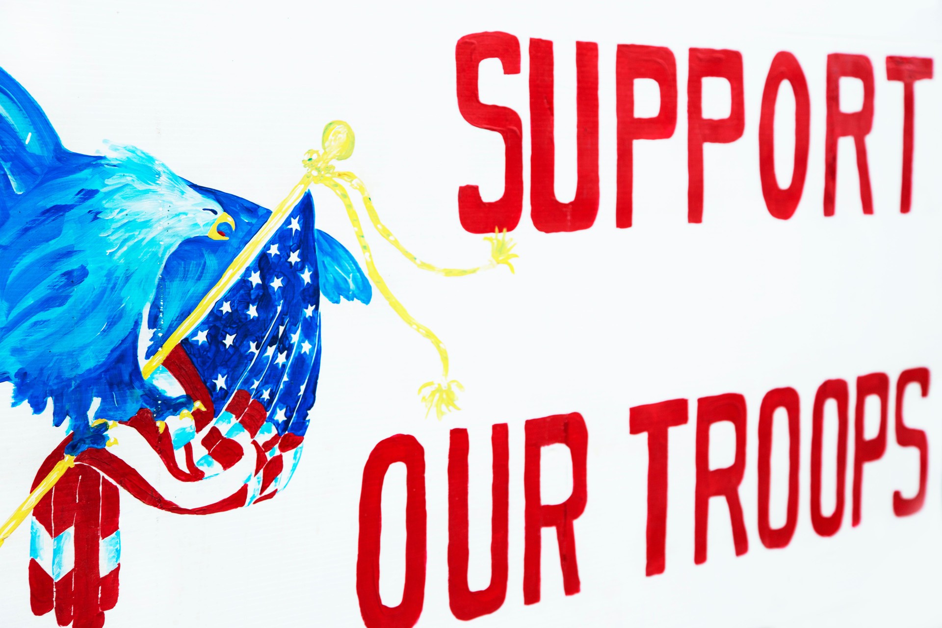 "Support our Troops" banner on fence in front of home.