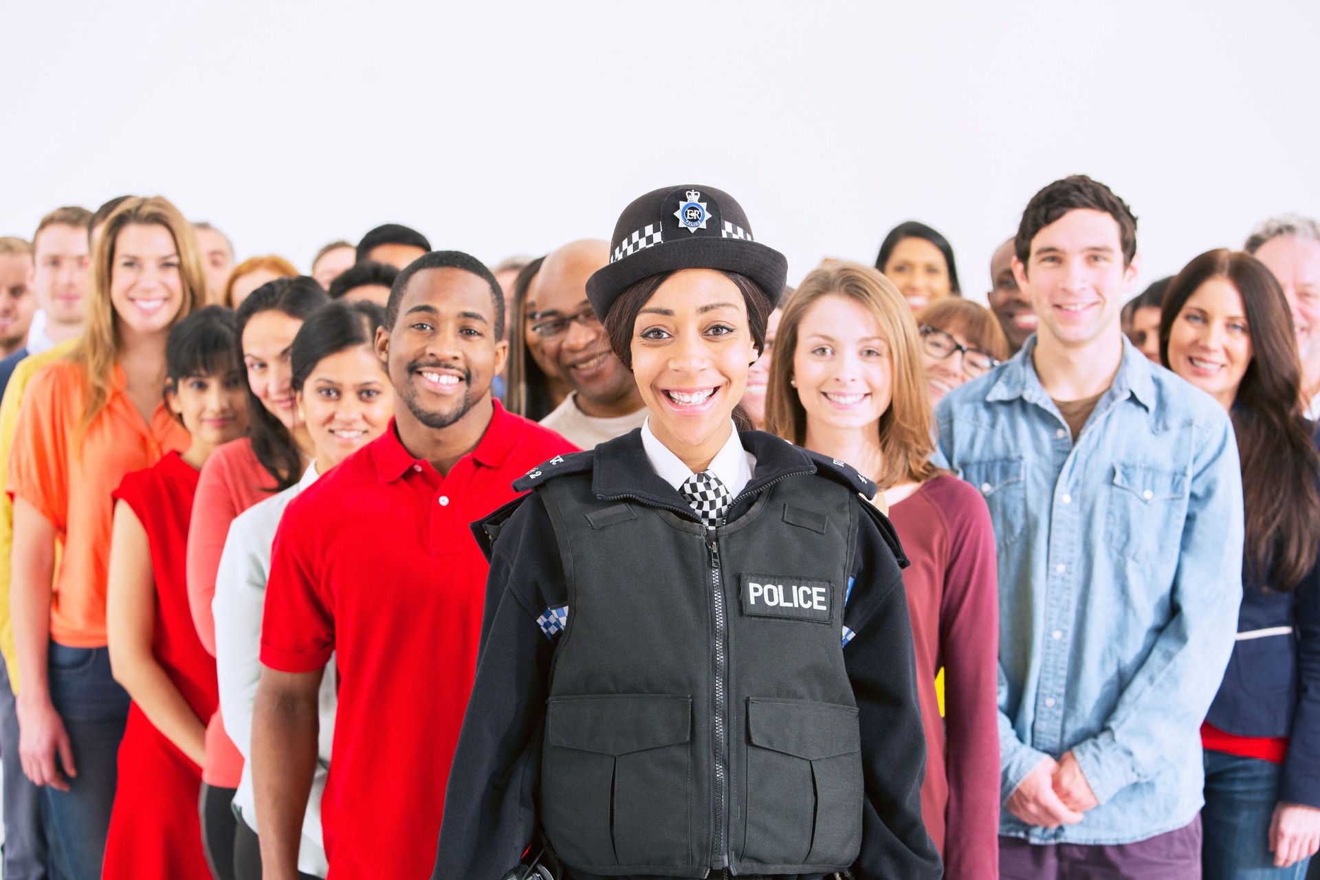 Portrait of smiling policewoman in front of large crowd